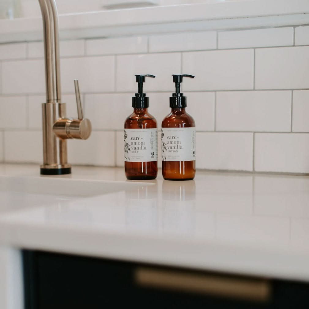 Two brown bottles with pump dispensers on a kitchen counter.