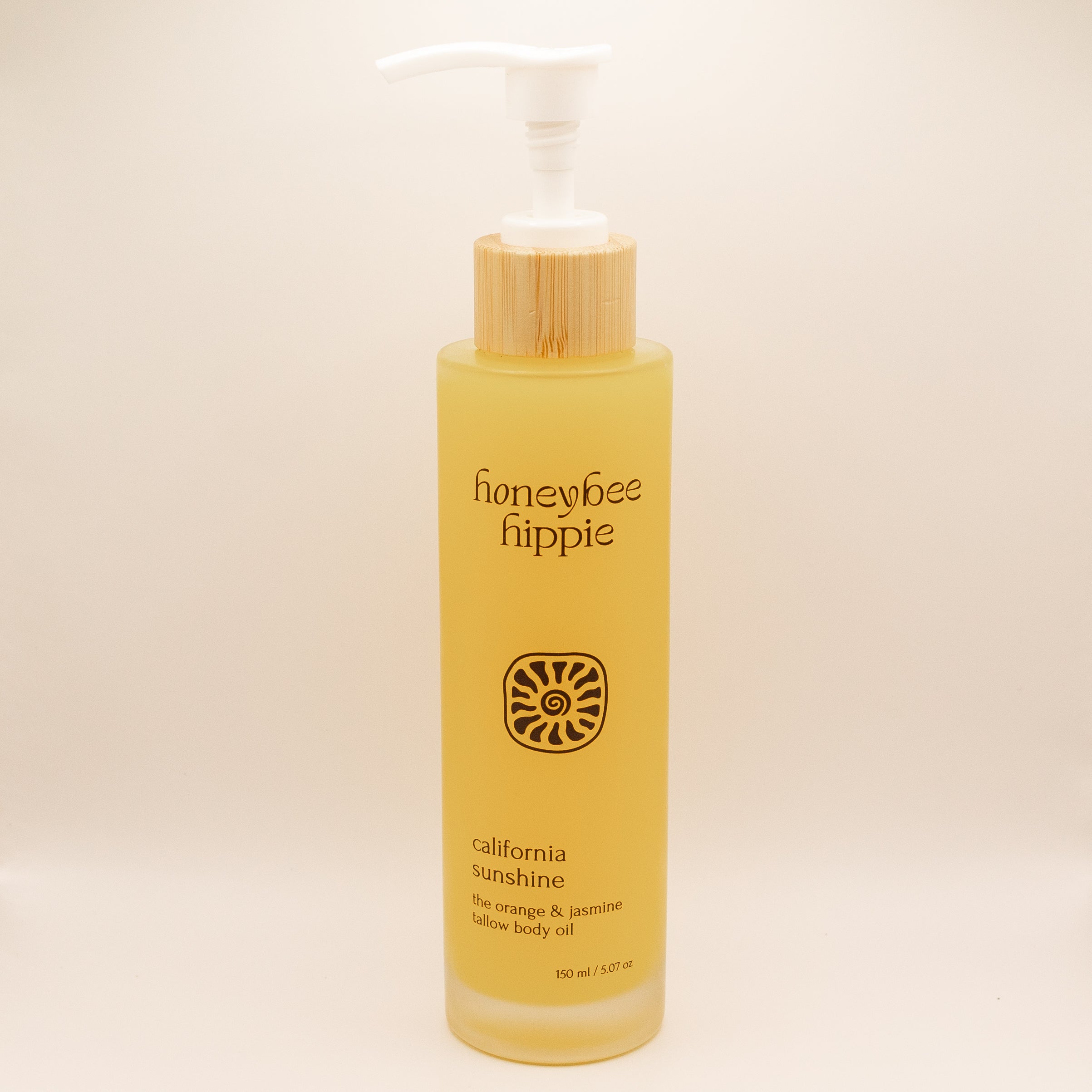 Yellow bottle of honeybee hippie California Sunshine body oil on a beige background