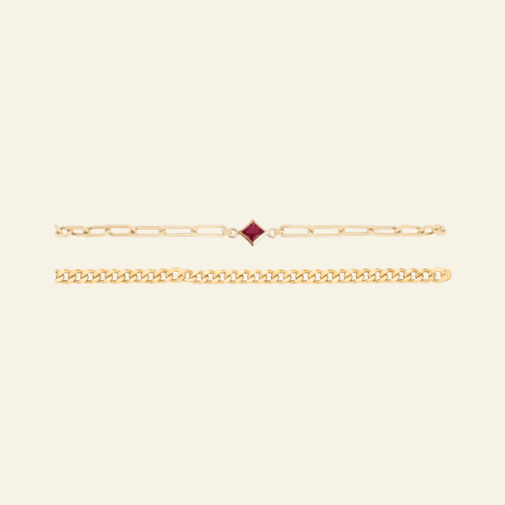 Gold bracelet with a red gemstone on a light gray background