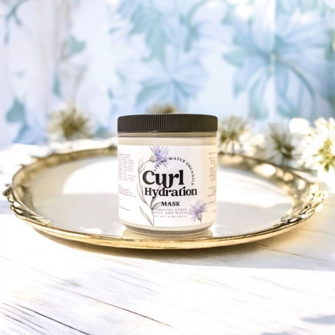 Jar of Curl Hydration Mask on a decorative tray with a blurred floral background