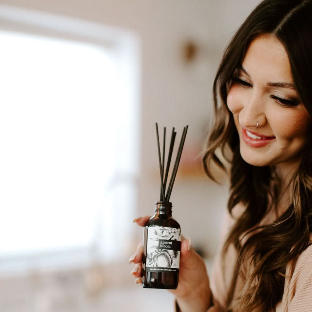 Woman holding a diffuser with a blurred background