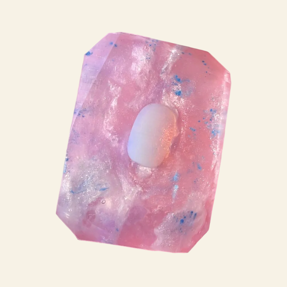 Pink crystal with a white sphere inside, held in a hand with a natural background