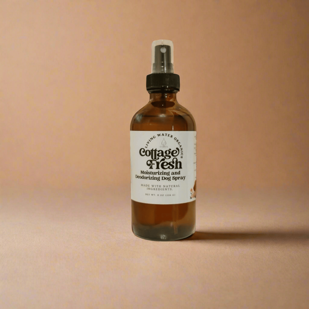 Bottle of Cottage Fresh body spray on a gold tray with white flowers in the background