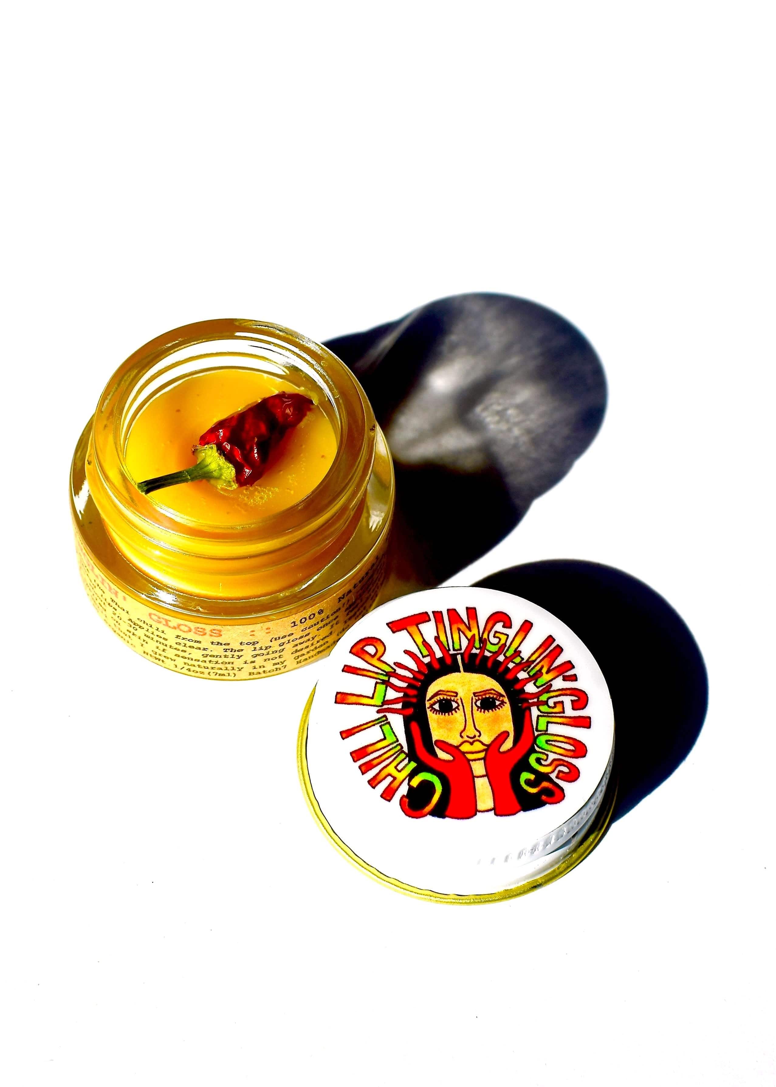 Yellow lip balm with a red chili pepper and a colorful label on a white background