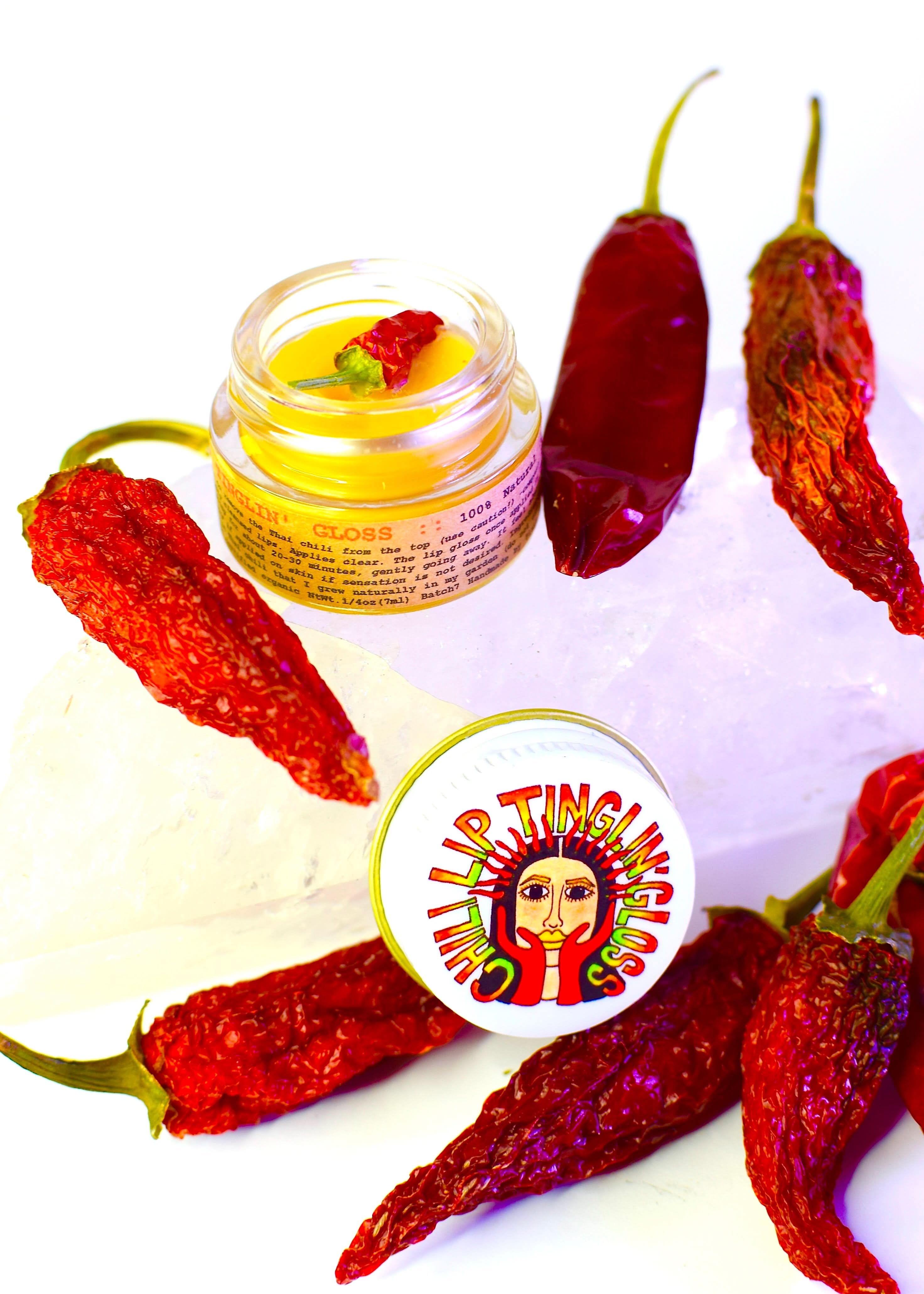 Balm jar with chili peppers on a white background, featuring a brand logo.