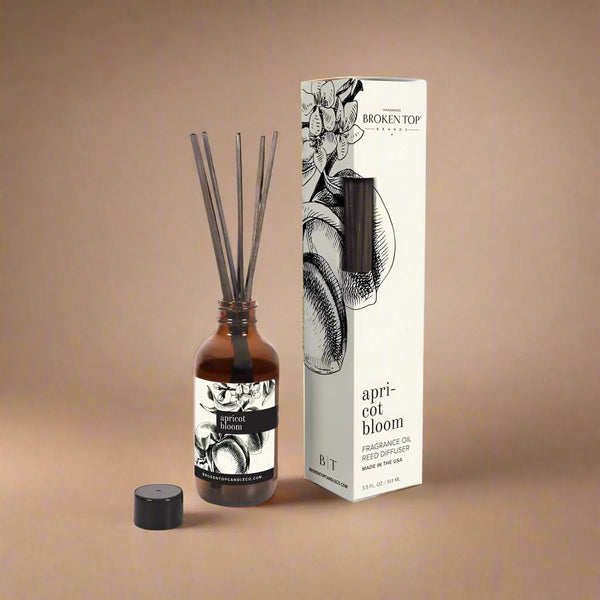 Reed diffuser set with bottle and packaging on a white background
