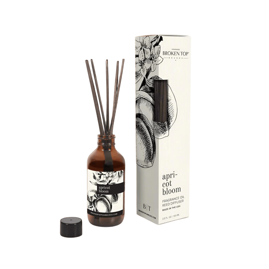 Reed diffuser set with bottle and packaging on a white background