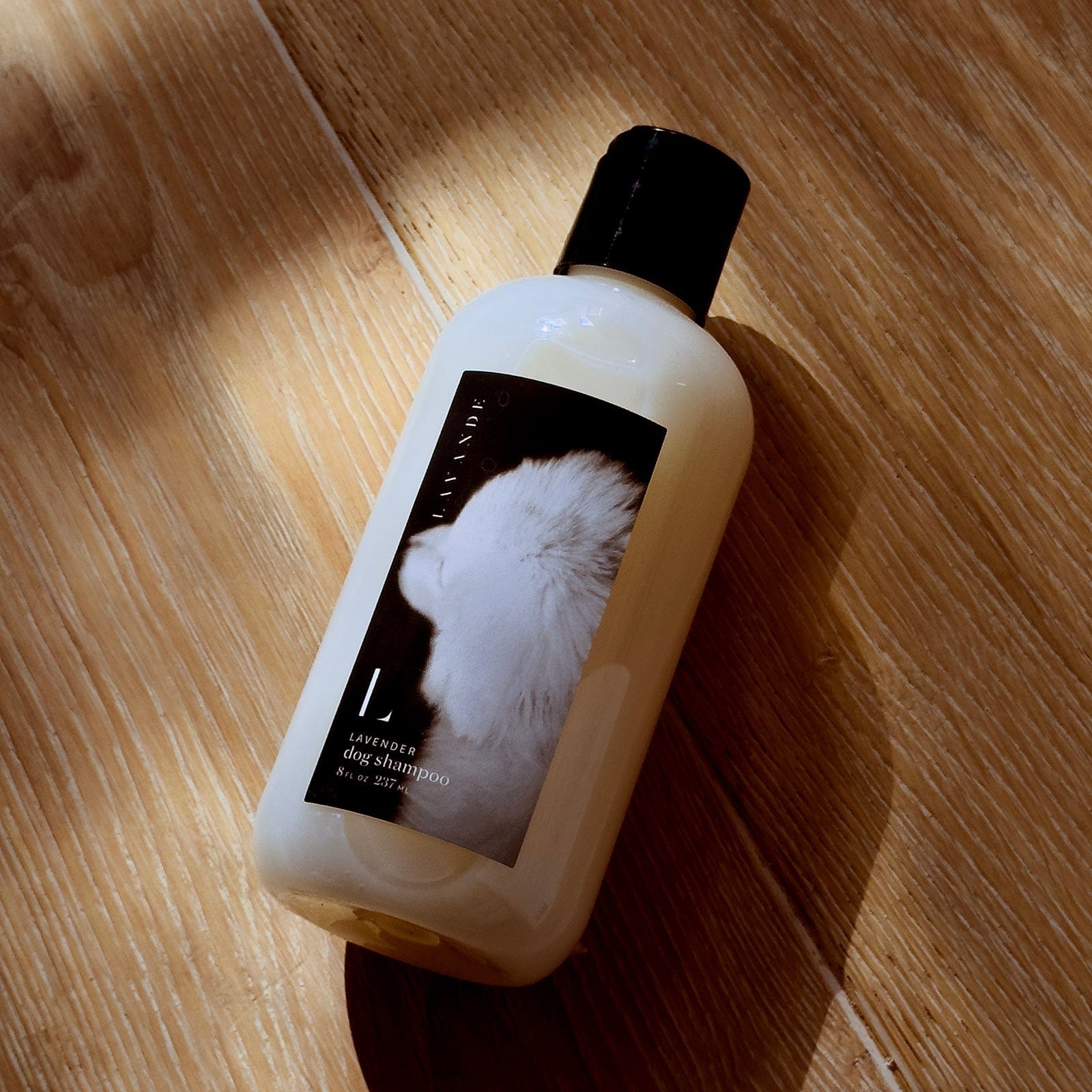 Dog shampoo bottle with a label on a wooden floor