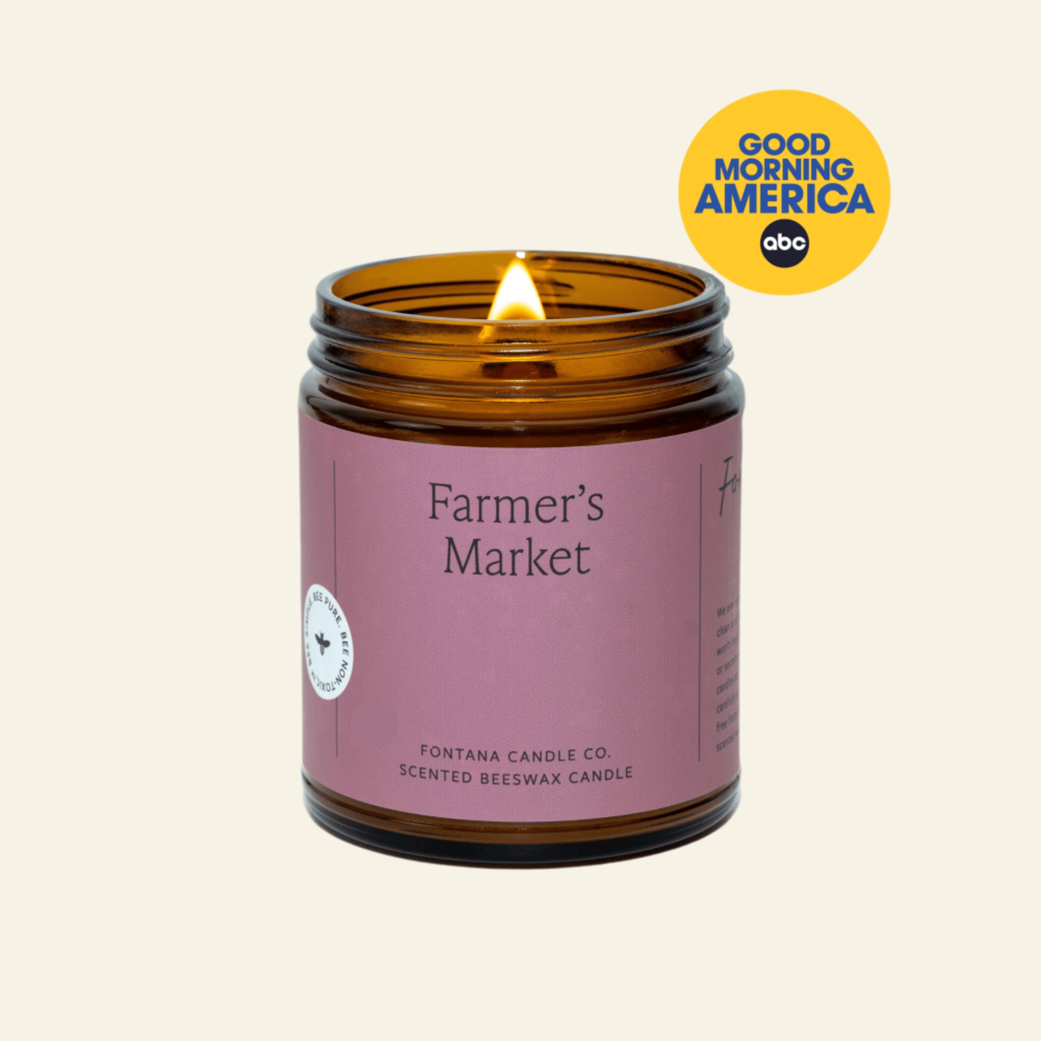 Scented candle in an amber jar with a purple label on a white background, featuring the &