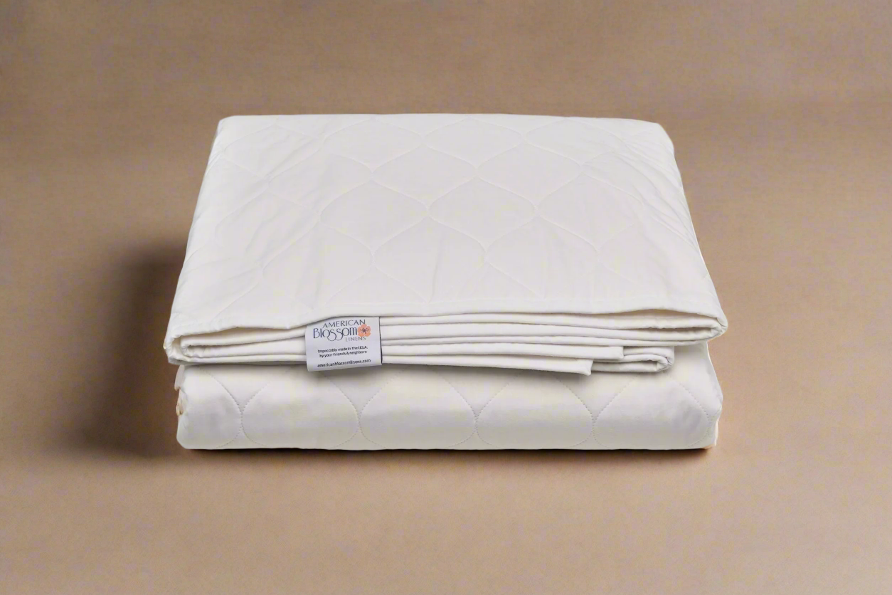 Folded white quilt with a label on a brown background
