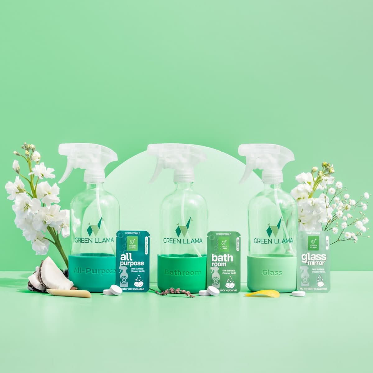 Set of Green Llama cleaning products on a green background with white flowers.