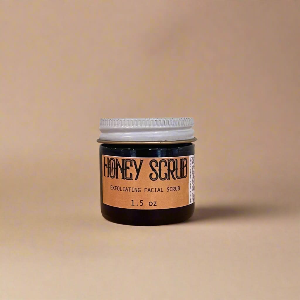 Jar of honey scrub on a wooden surface with a light gray background