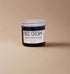 Jar of face cream with a label on a beige background
