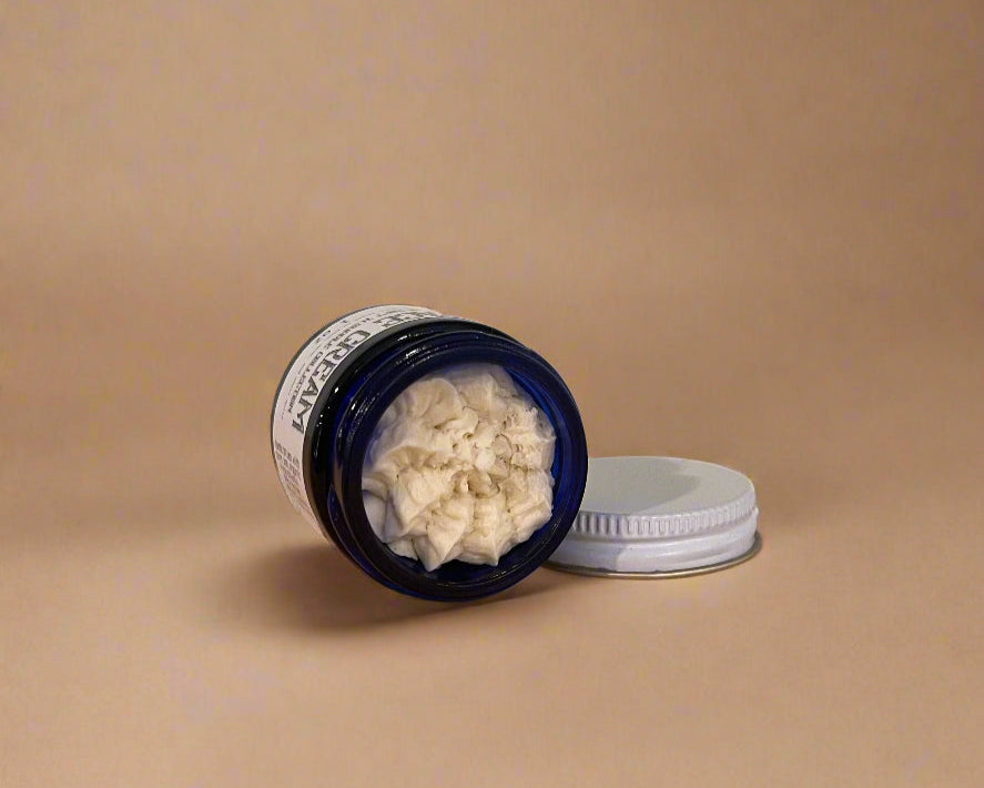 Jar of cream with a lid on a beige background