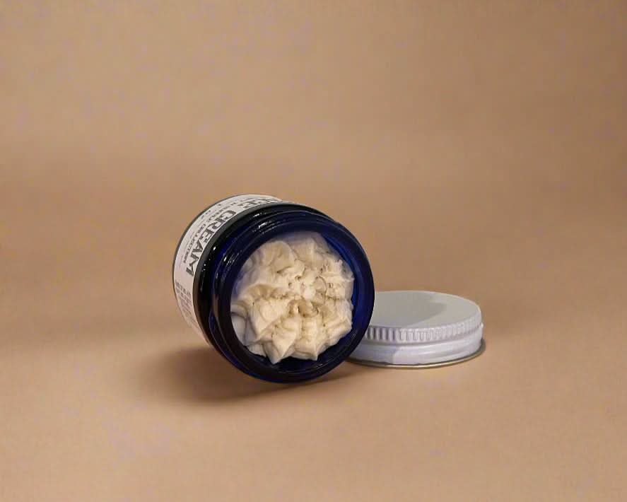 Jar of cream with a lid on a beige background