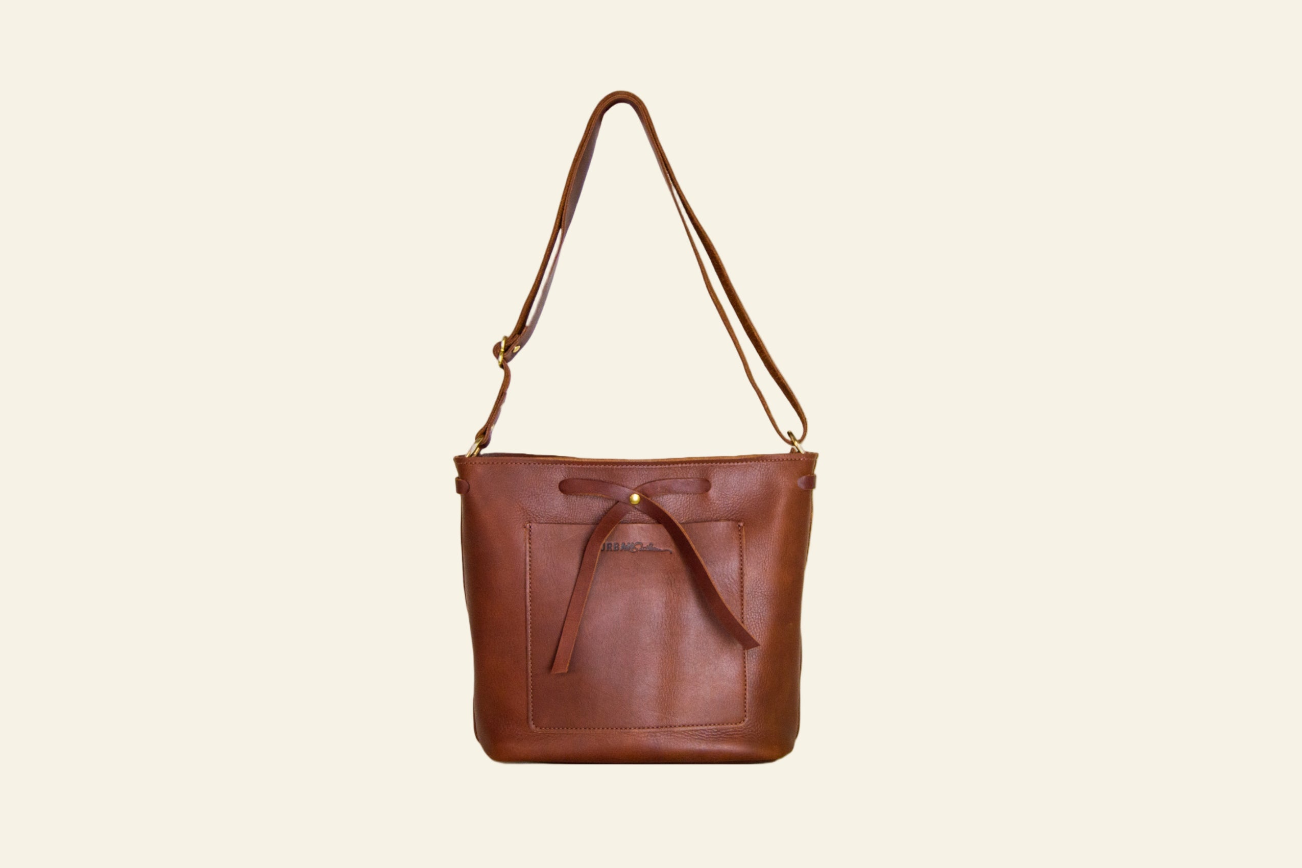 Brown leather handbag with a strap on a white background