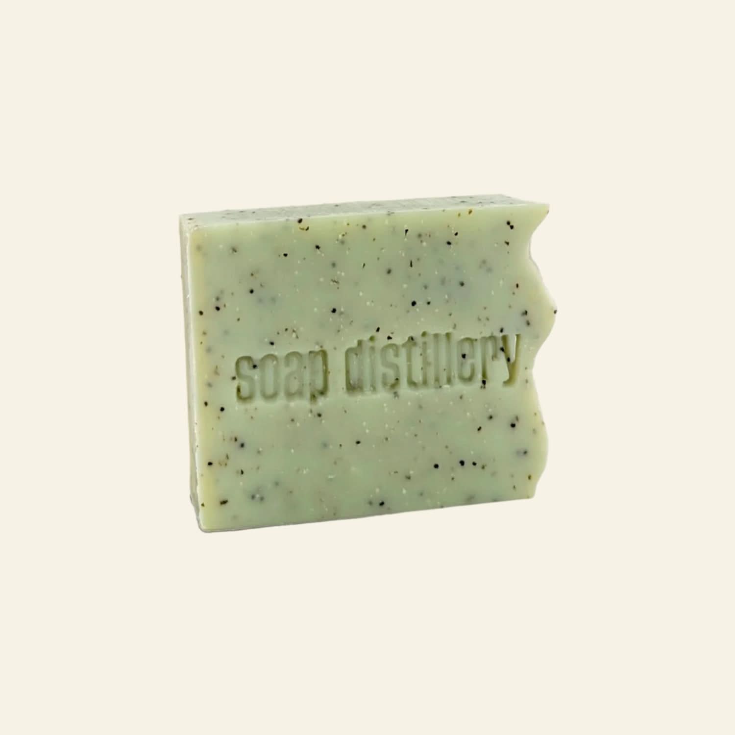 Green soap bar with specks from Soap Distillery on a white background