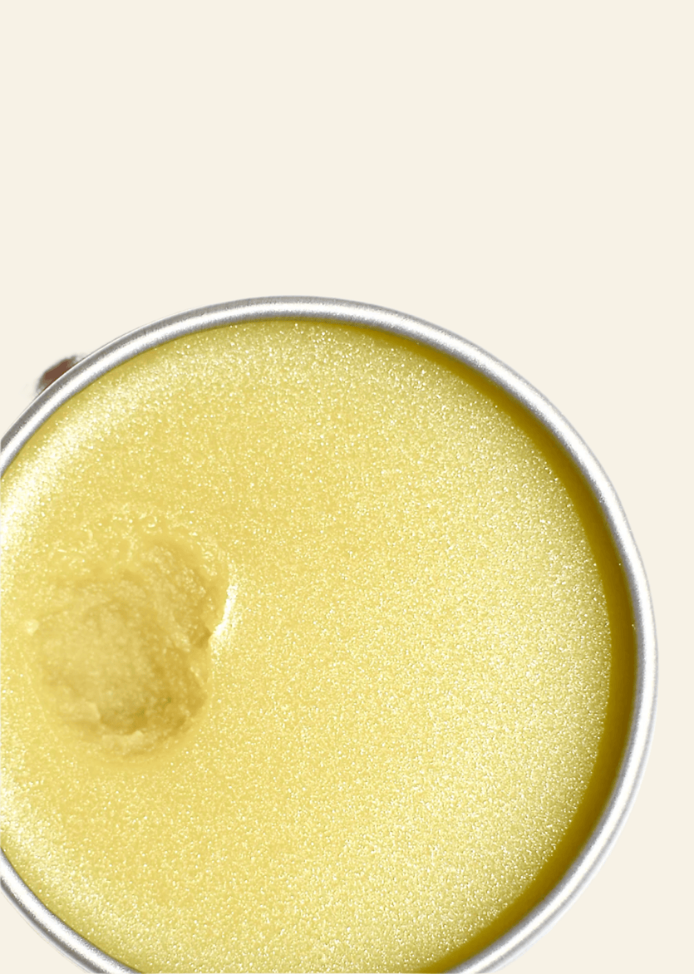 Close-up of a jar of yellow cream on a white background