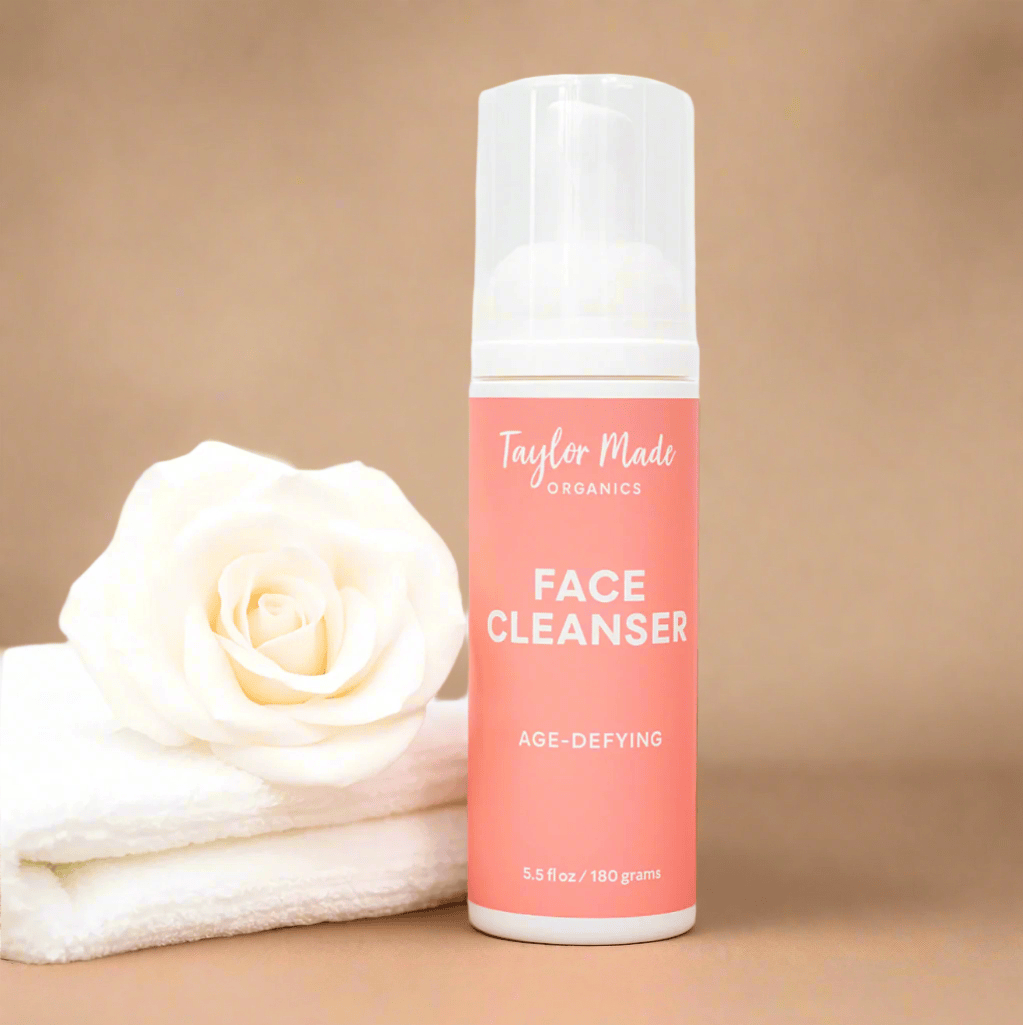 Taylor Made Organics face cleanser bottle with a white rose on a wooden surface