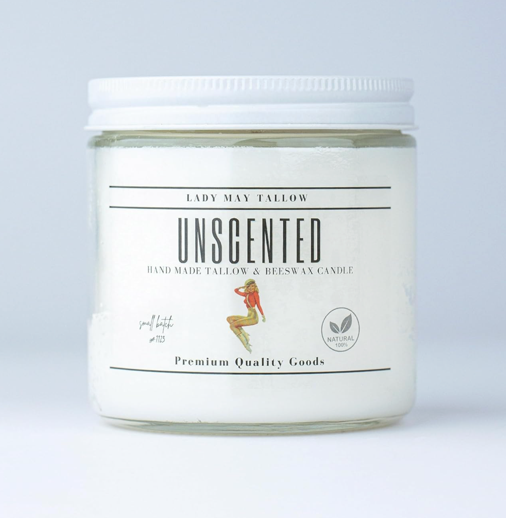 Unscented candle in a glass jar with a white label on a light gray background