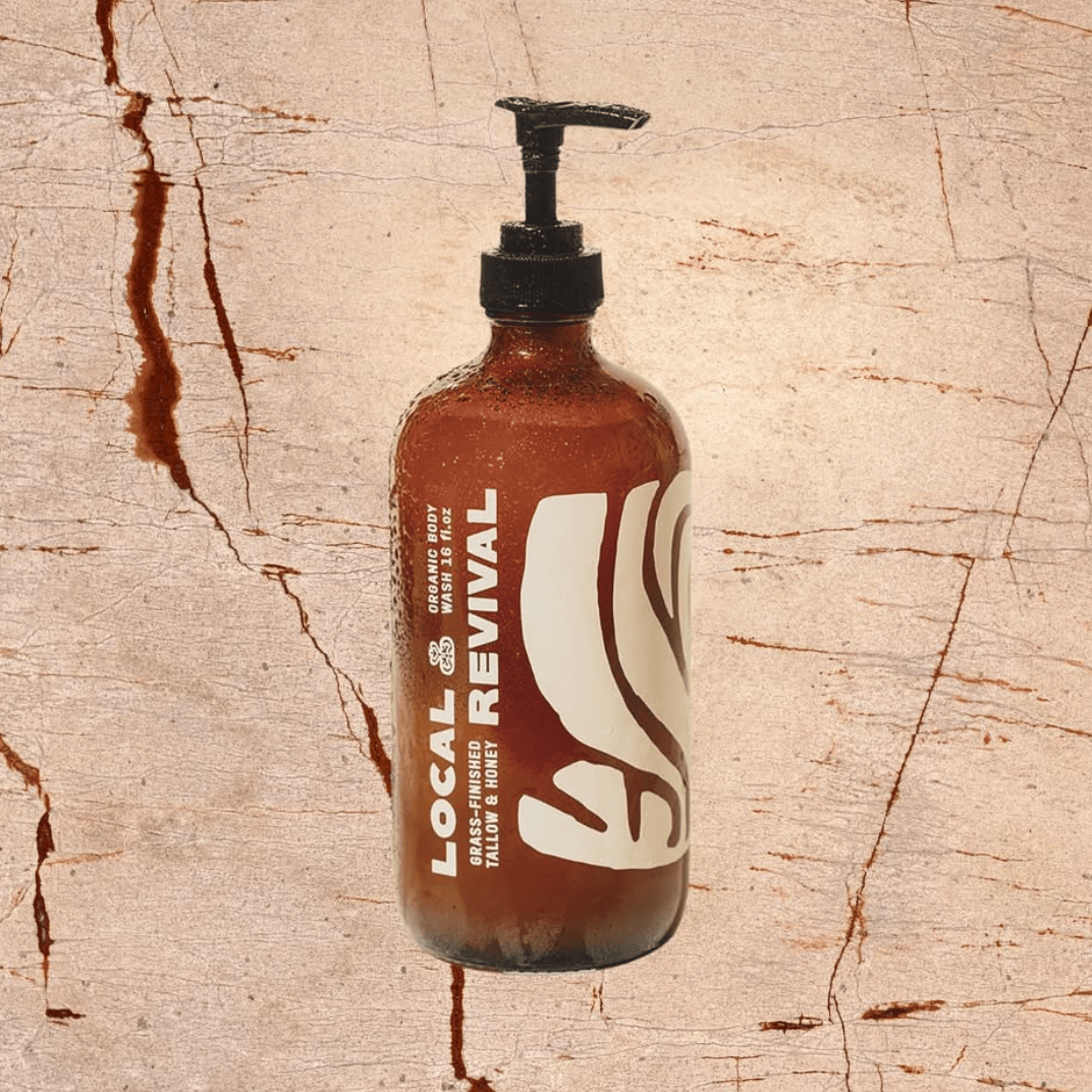 Bottle of Local Revival hair product on a textured beige background
