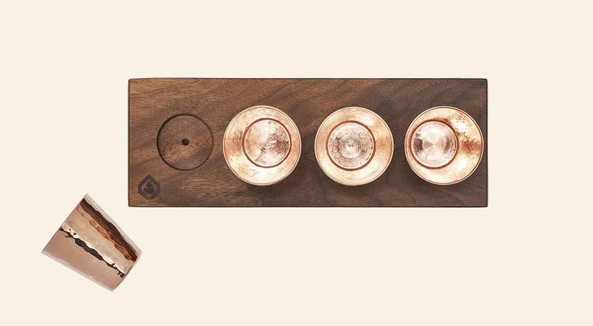 Wooden light fixture with copper-colored lights on a white background