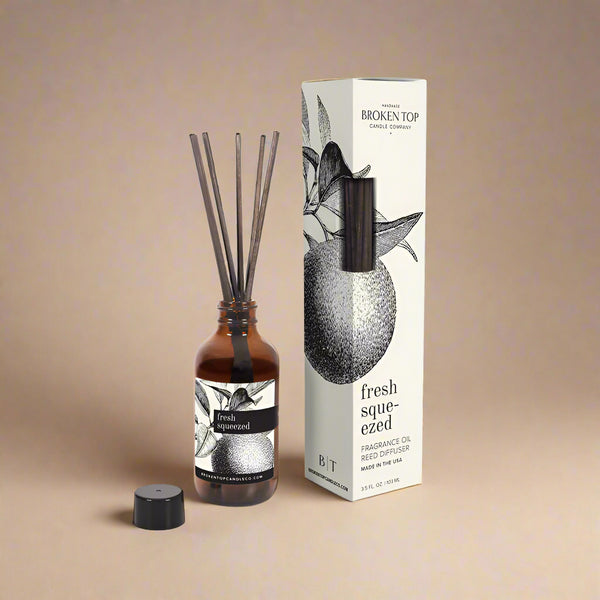 Fragrance oil diffuser with reeds and packaging on a white background