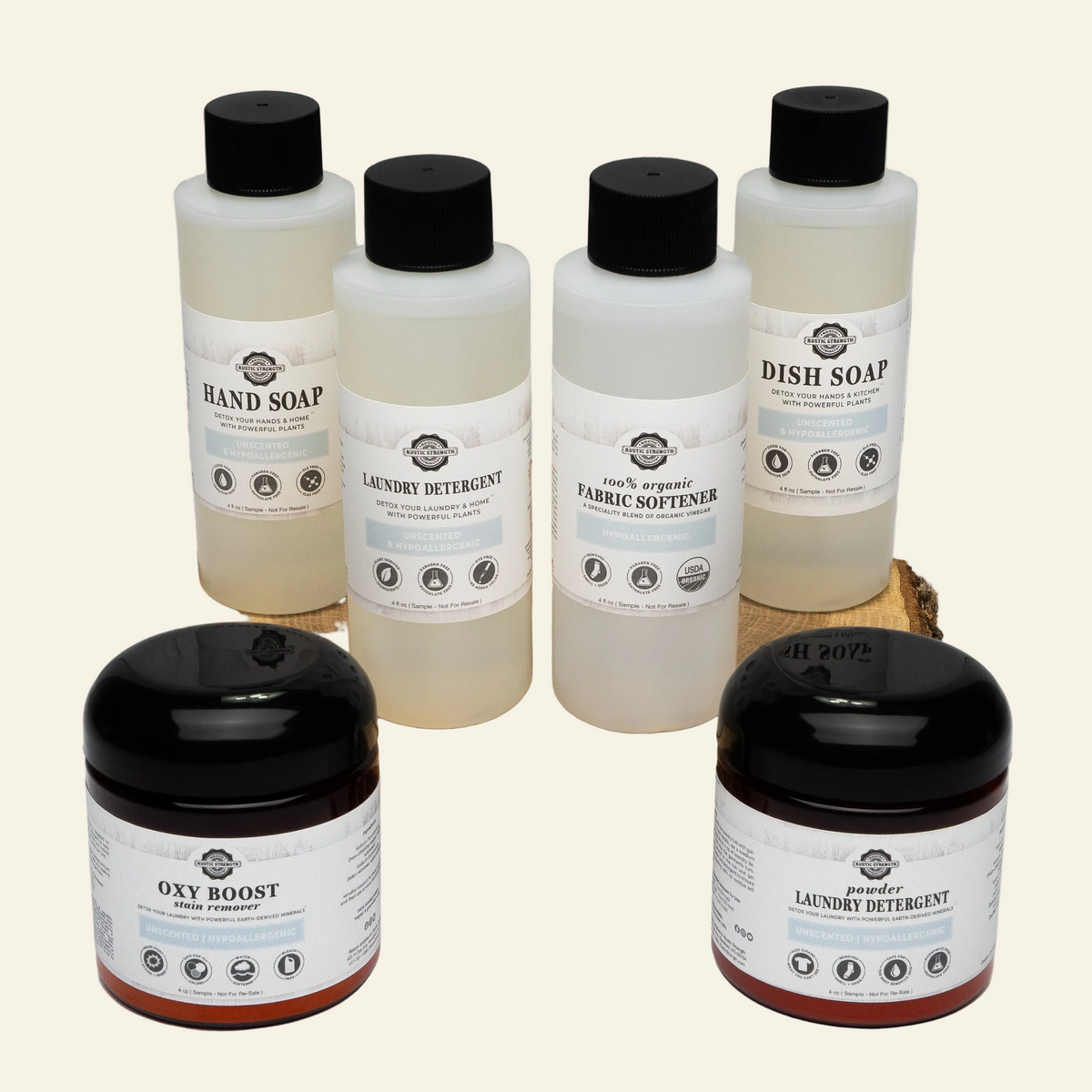 Set of natural cleaning products including bottles and jars on a wooden block with a white background.