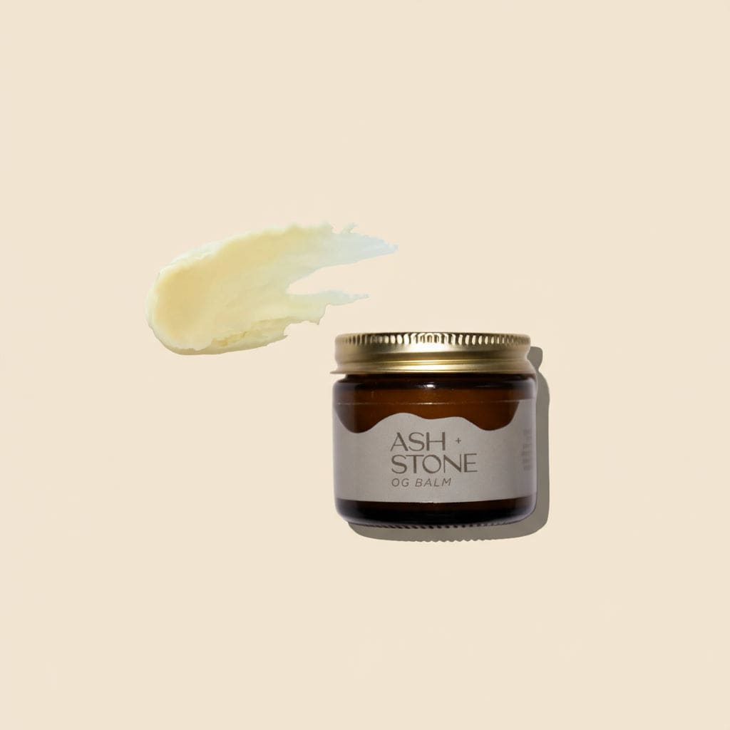 Jar of Ash + Stone balm with a swatch of balm on a white background