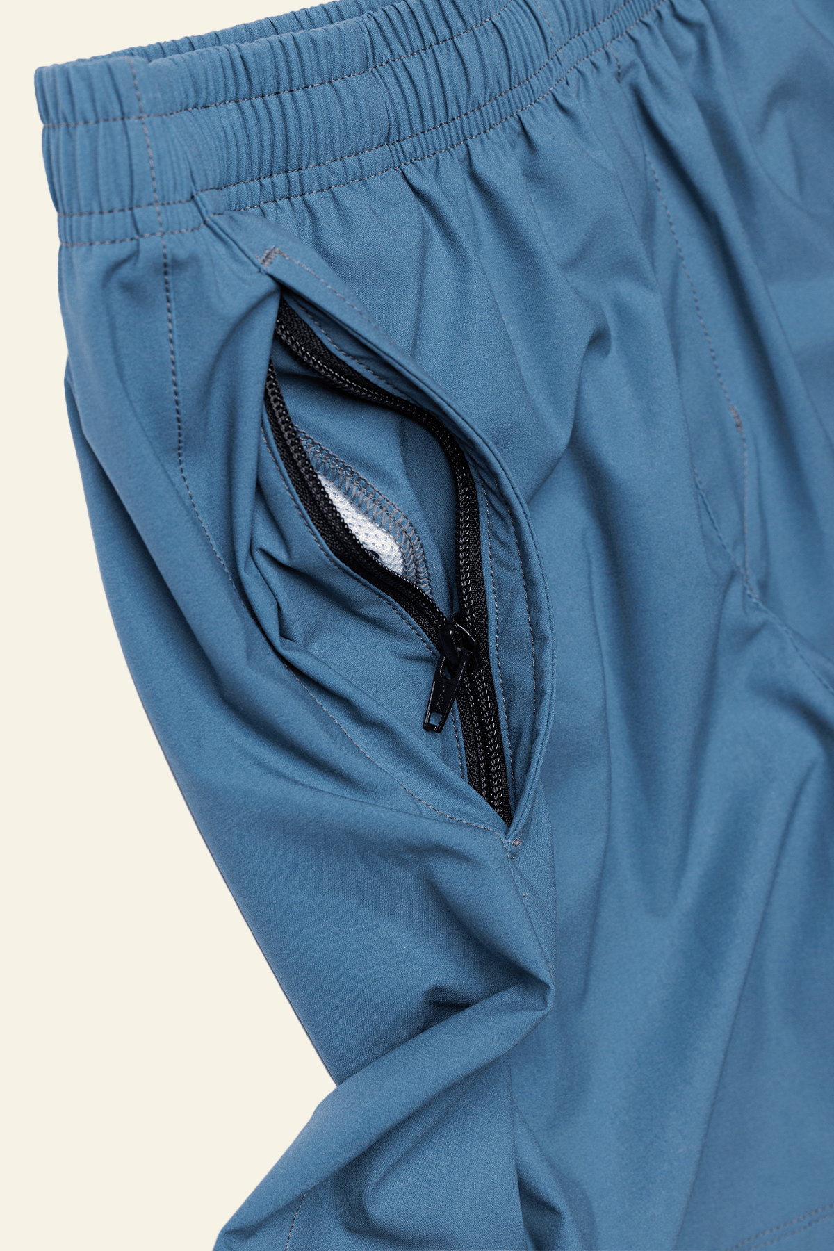 Close-up of blue shorts with a zipper pocket on a white background