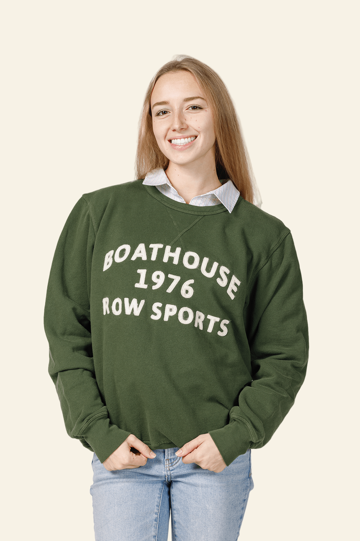 Person wearing a green sweatshirt with text, standing against a white background