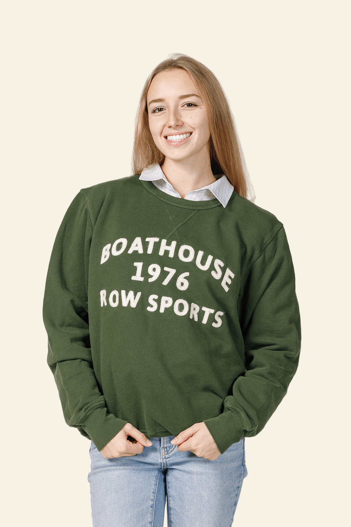 Person wearing a green sweatshirt with text, standing against a white background