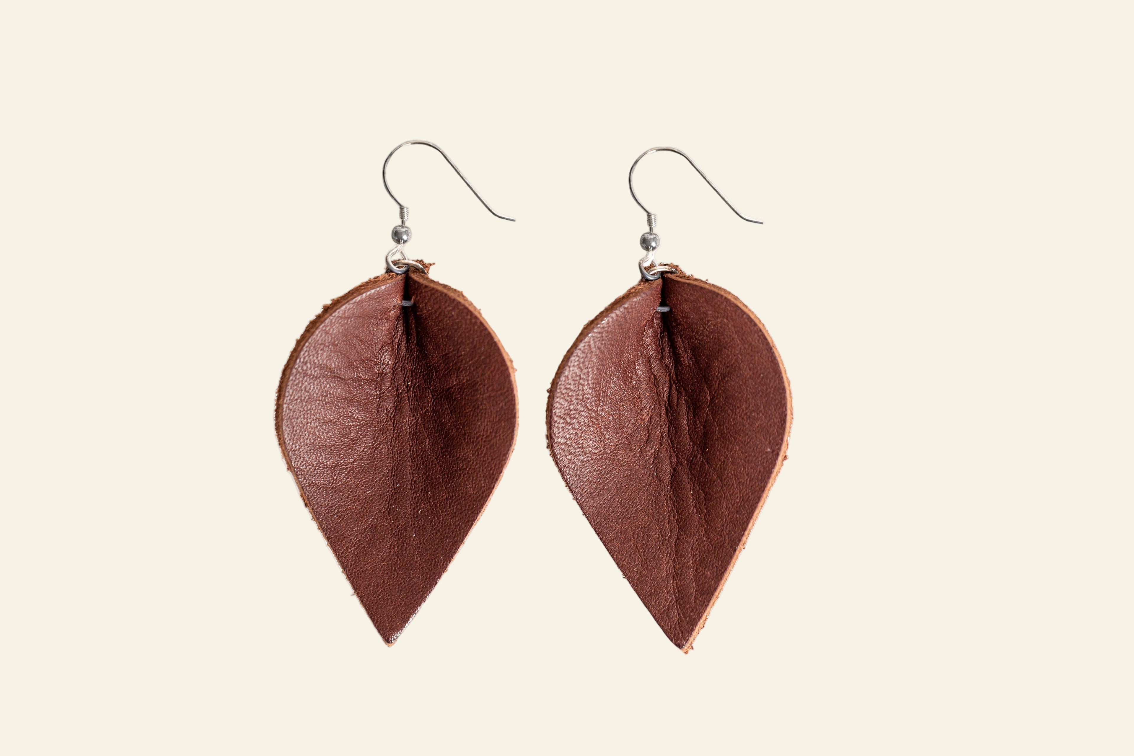 Brown leaf-shaped earrings on a white background