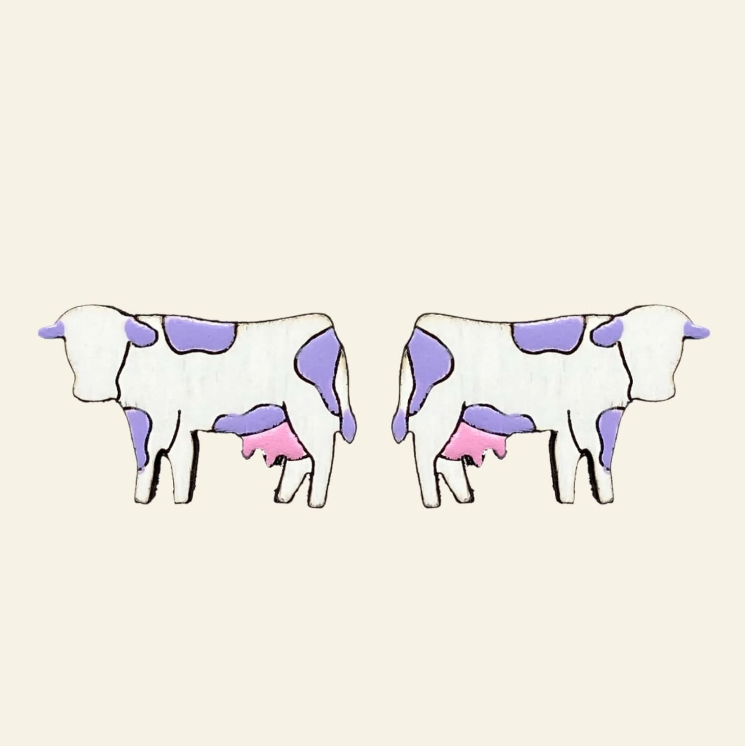 Pair of cow-shaped earrings with purple and pink spots on a white background