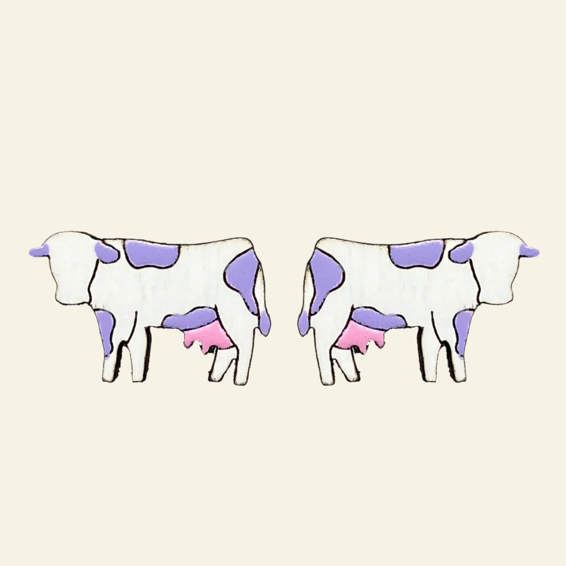 Pair of cow-shaped earrings with purple and pink spots on a white background