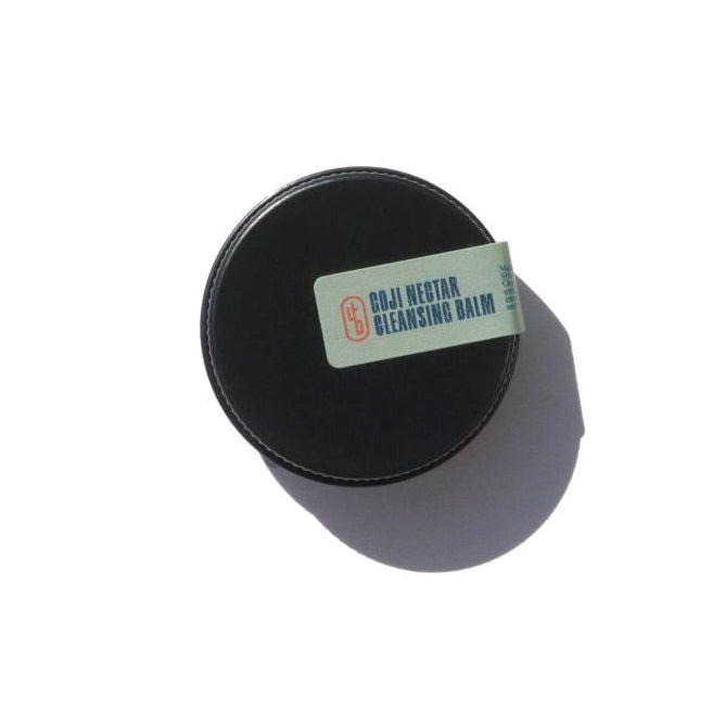 Black tin container with a label on a white background