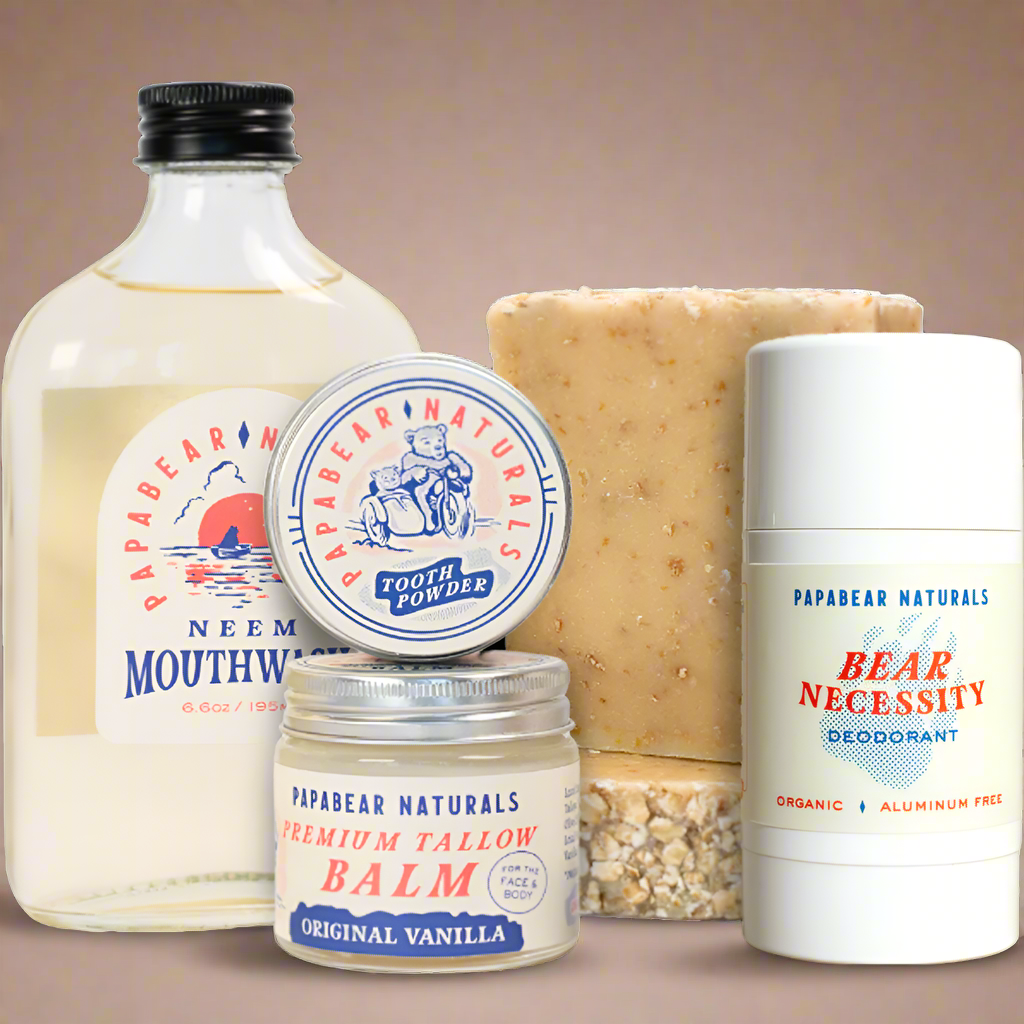 Collection of Papabear Naturals products including mouthwash, tooth powder, balm, soap, and deodorant on a white background.