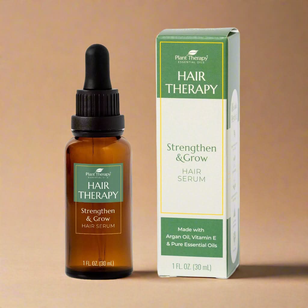 Hair serum bottle with dropper and packaging on a white background