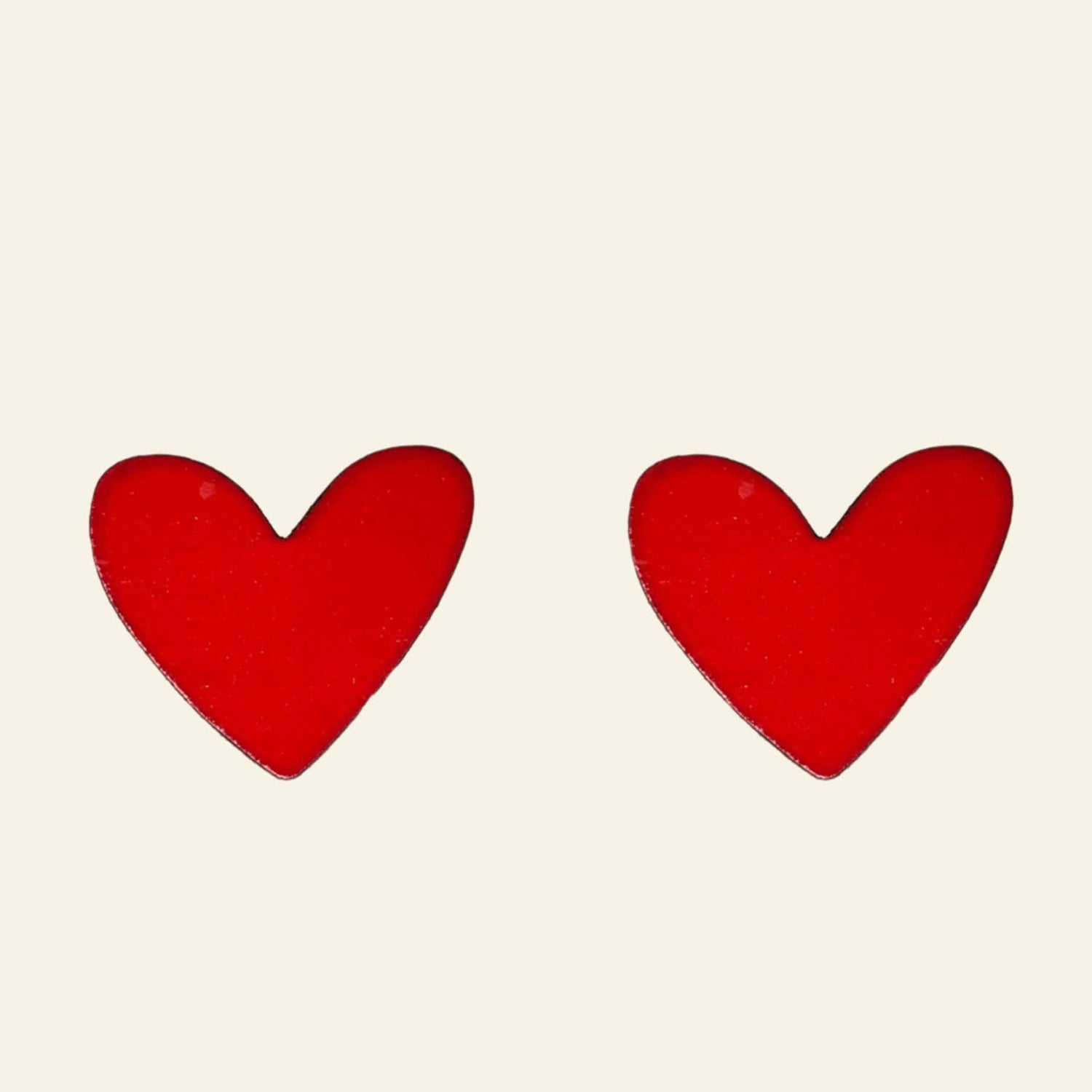 Red heart-shaped earrings on a white background