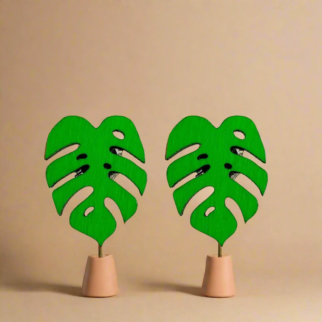 Green leaf-shaped earrings on a white background