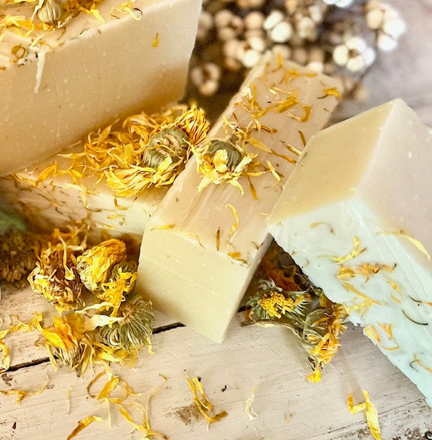 Bar of soap with yellow flowers on a wooden surface