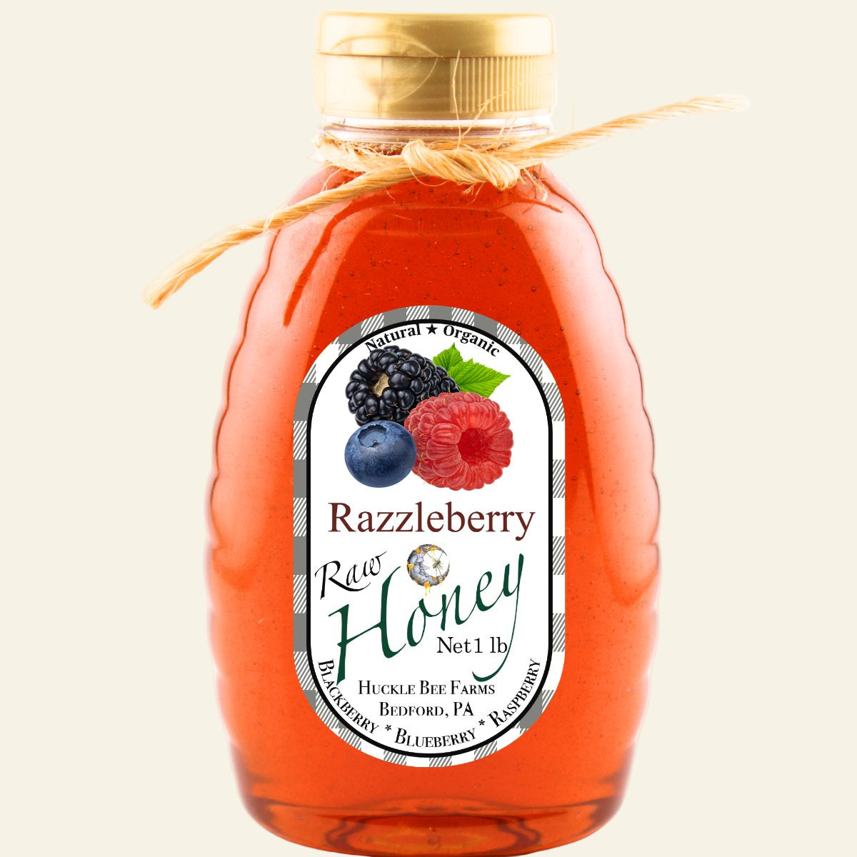 Bottle of Razzleberry Raw Honey with a label featuring berries on a white background