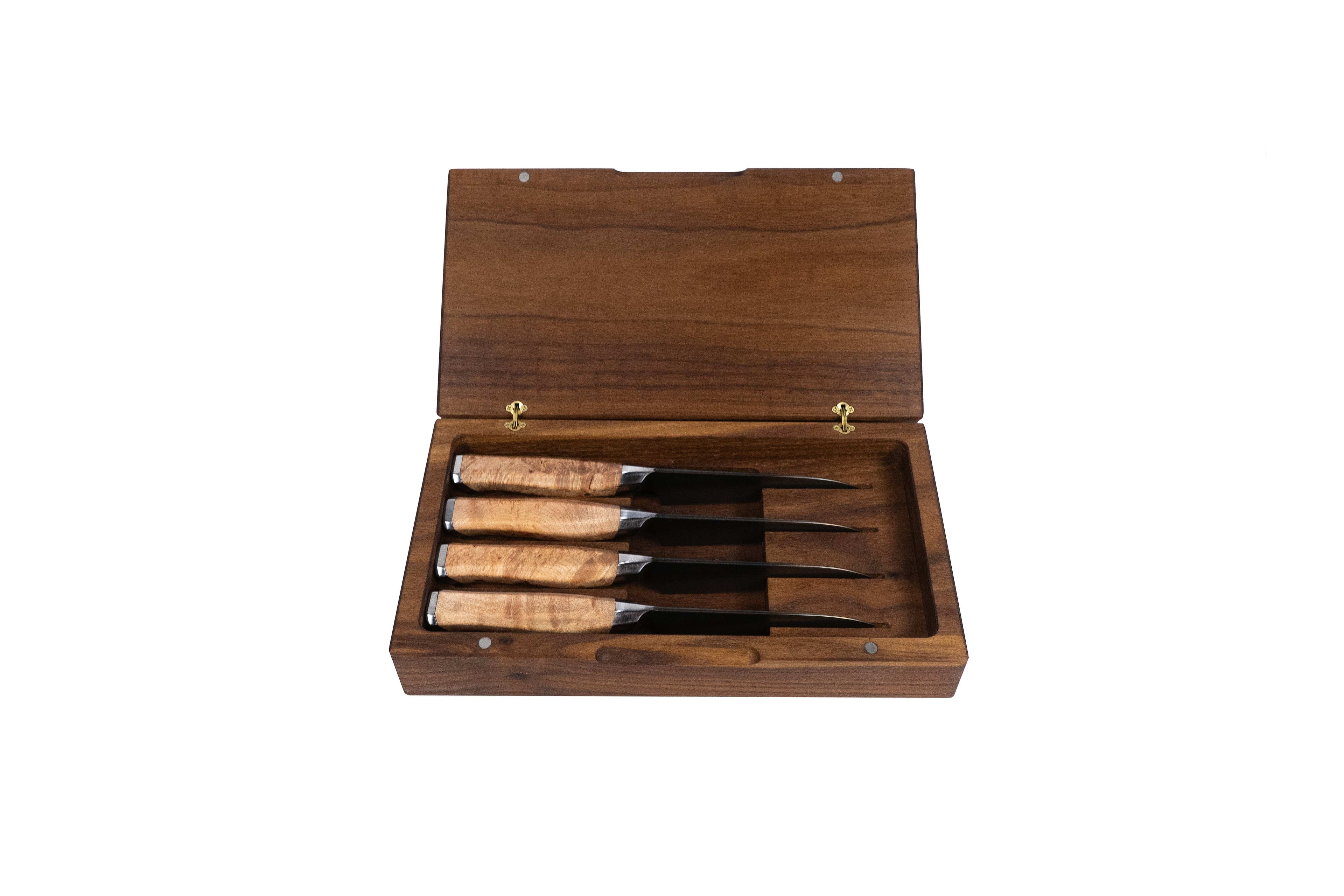 Set of four steak knives in a wooden box on a white background