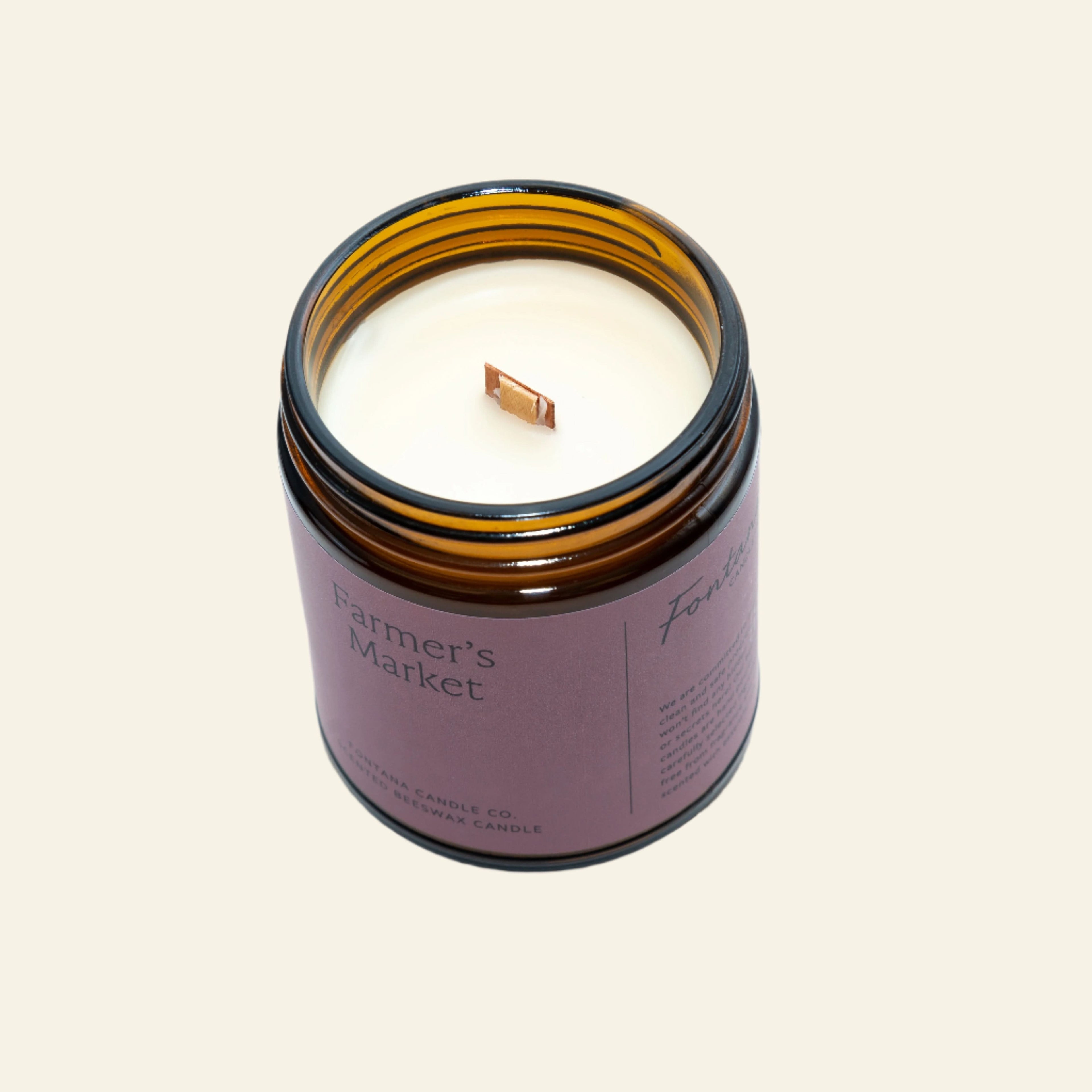 Candle in an amber jar labeled &