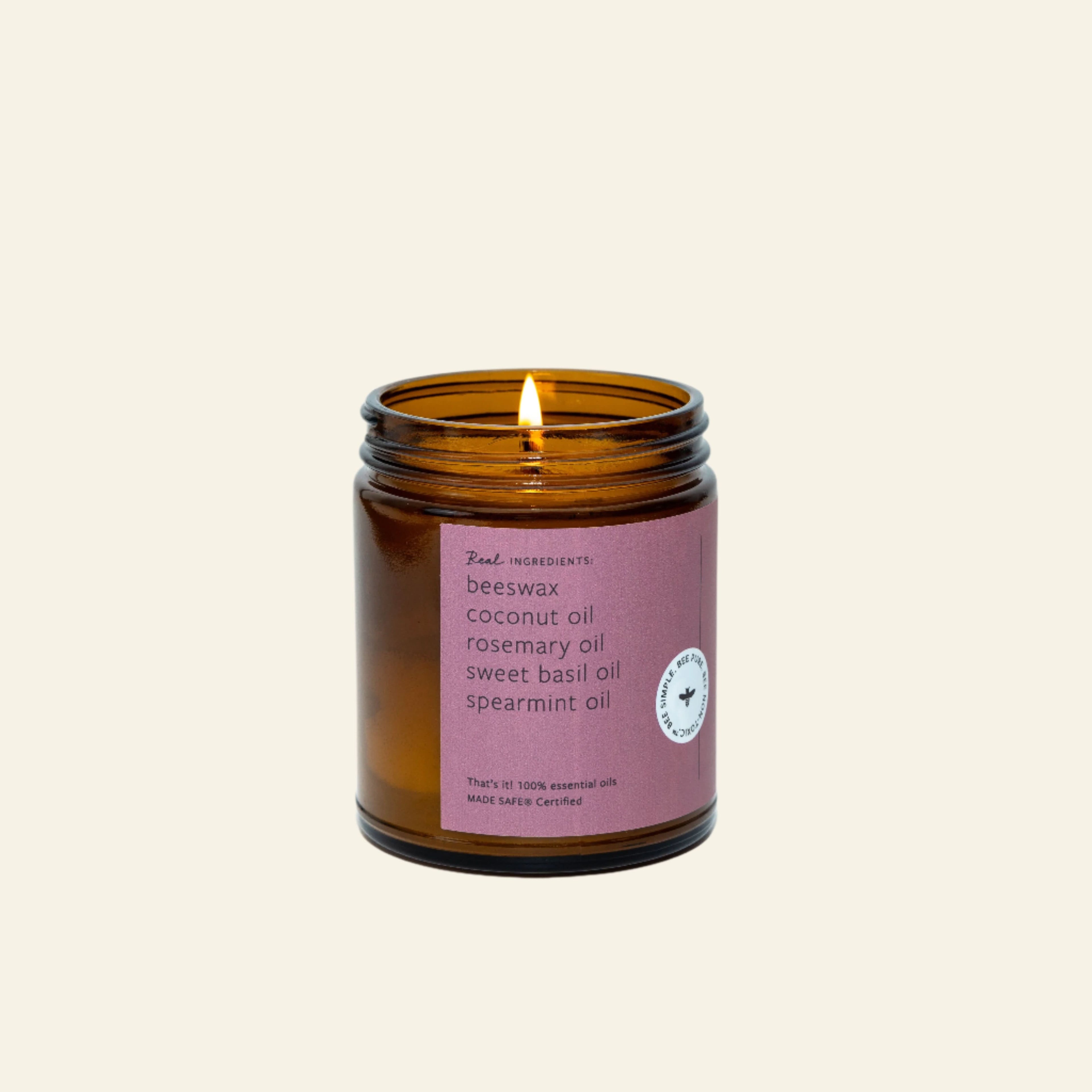 Candle in an amber jar with a purple label on a white background