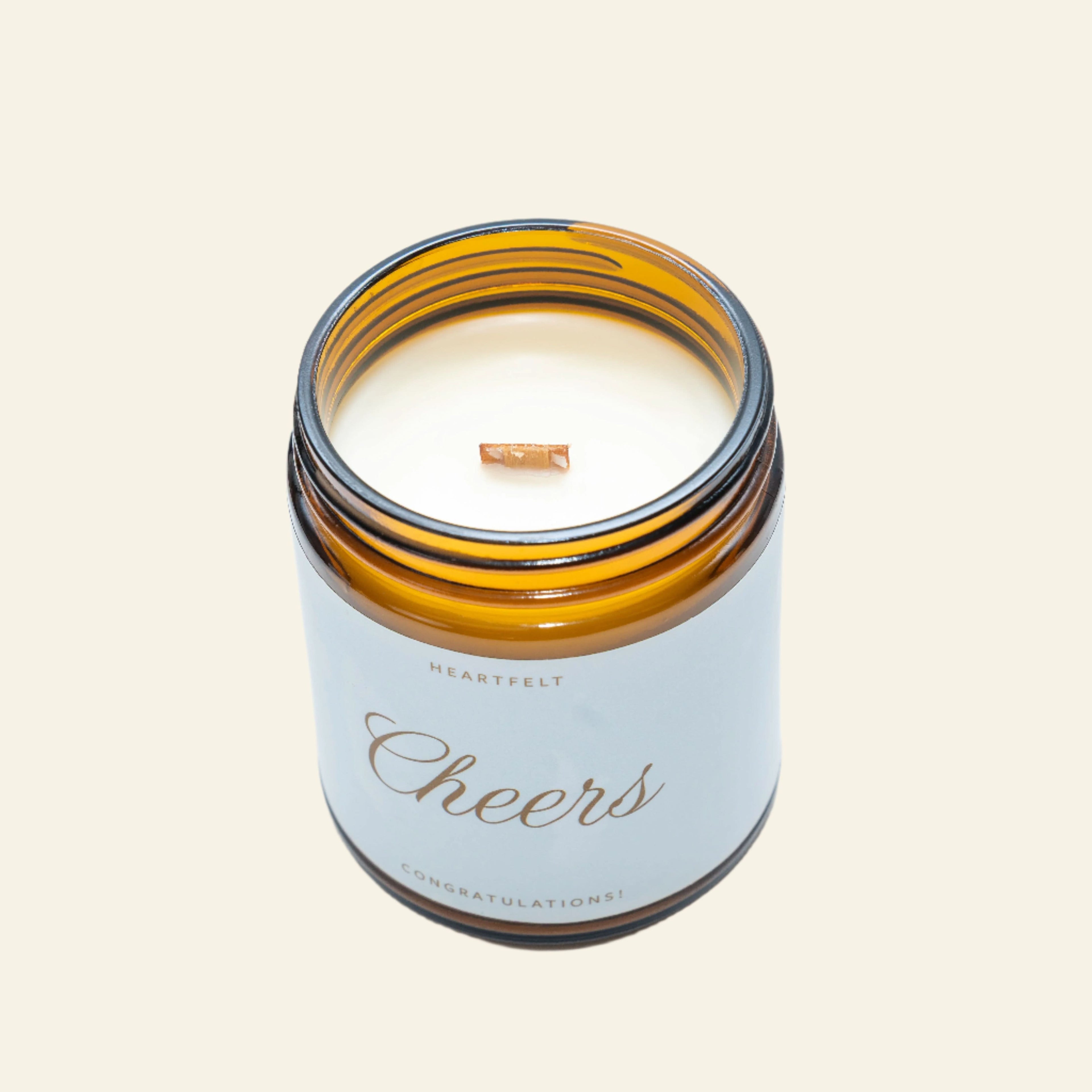 Candle in an amber glass jar with a white label on a light gray background