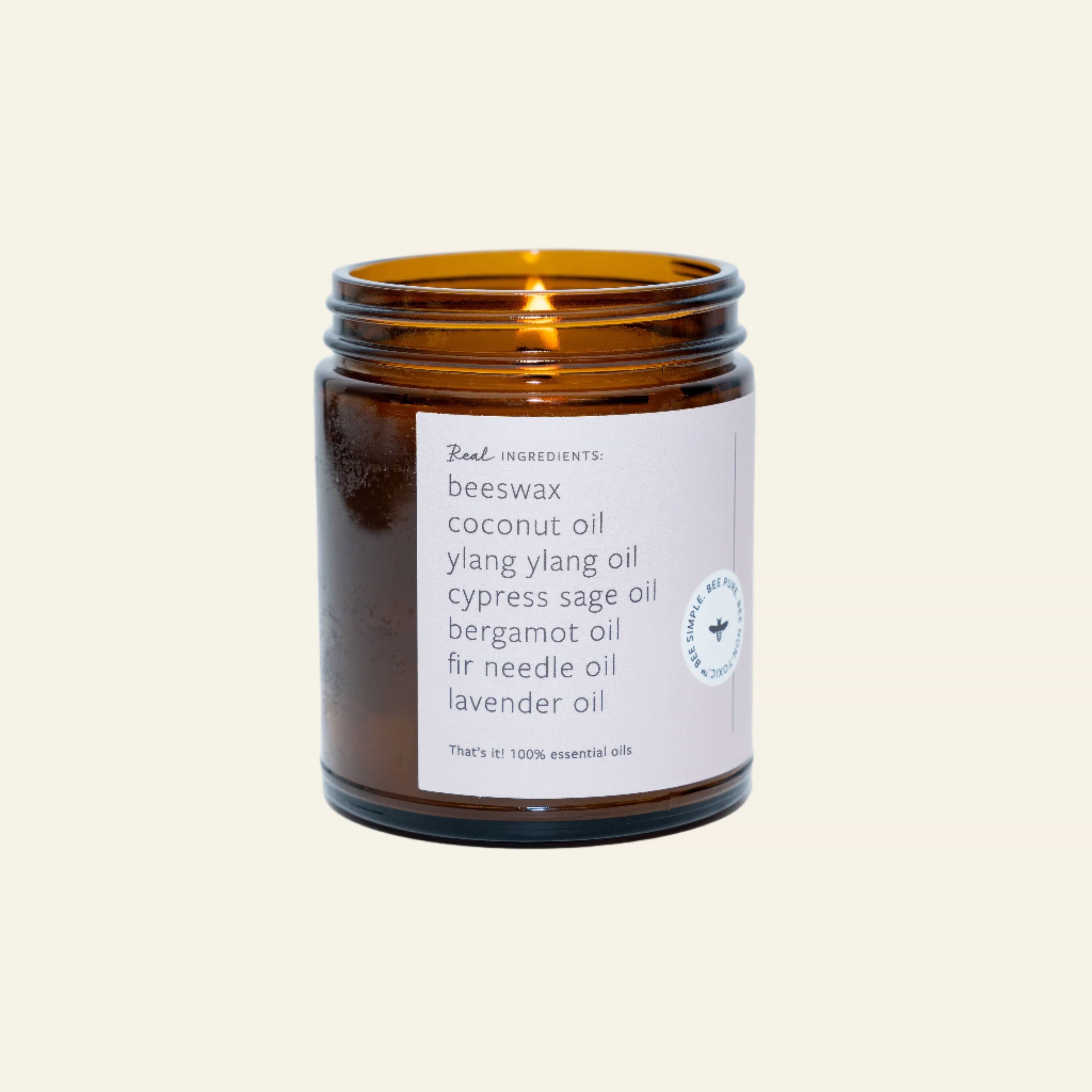 Candle in an amber jar with a white label on a light gray background