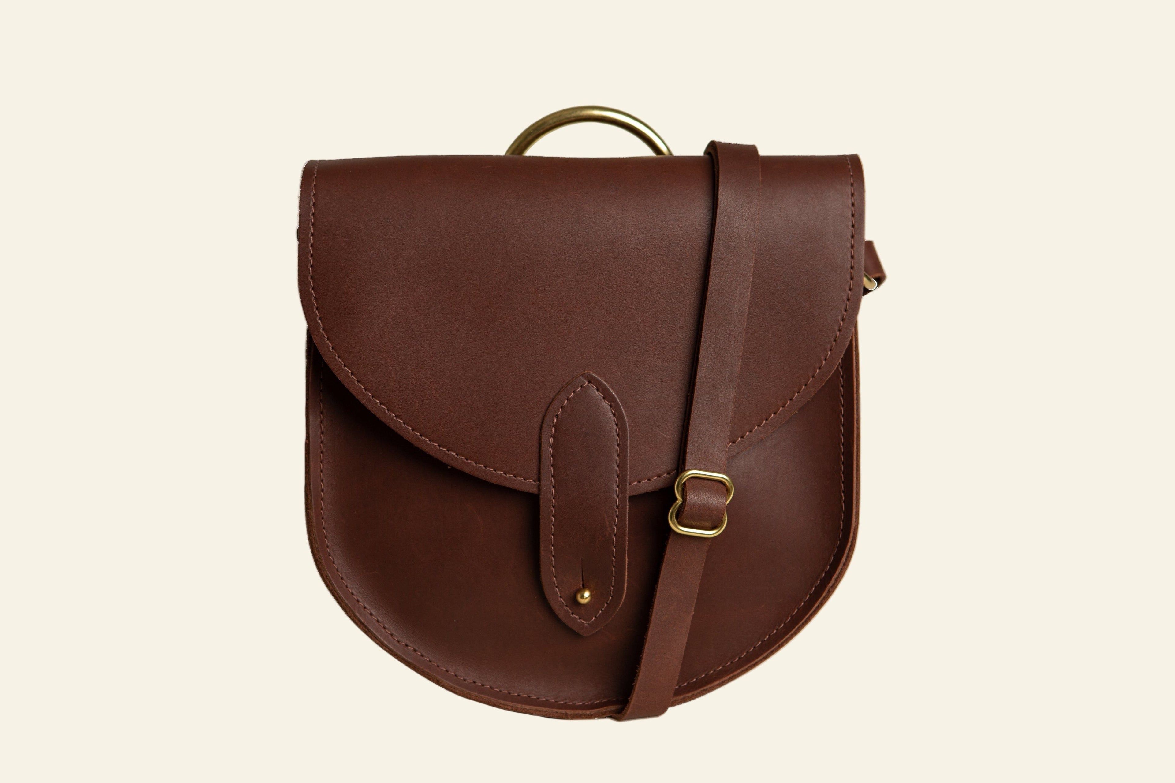 Brown leather bag with a strap on a white background