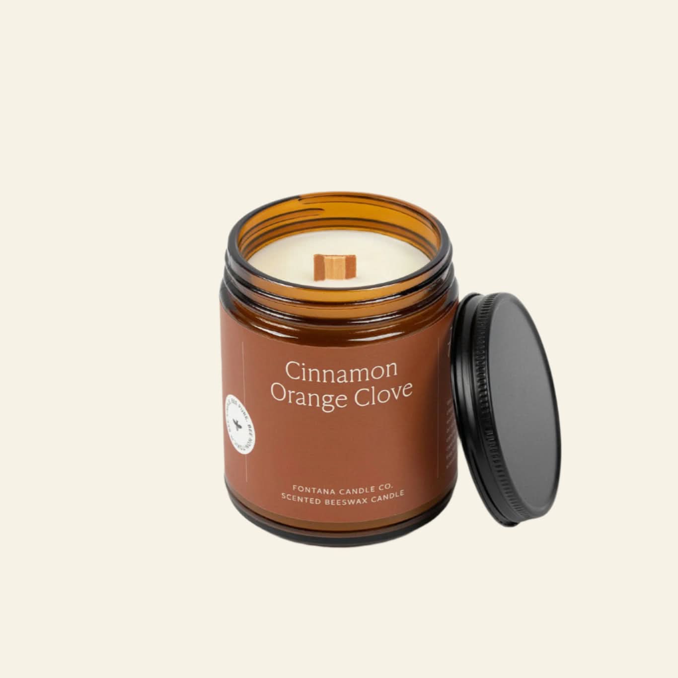 Cinnamon Orange Clove candle in a brown jar with a black lid on a white background