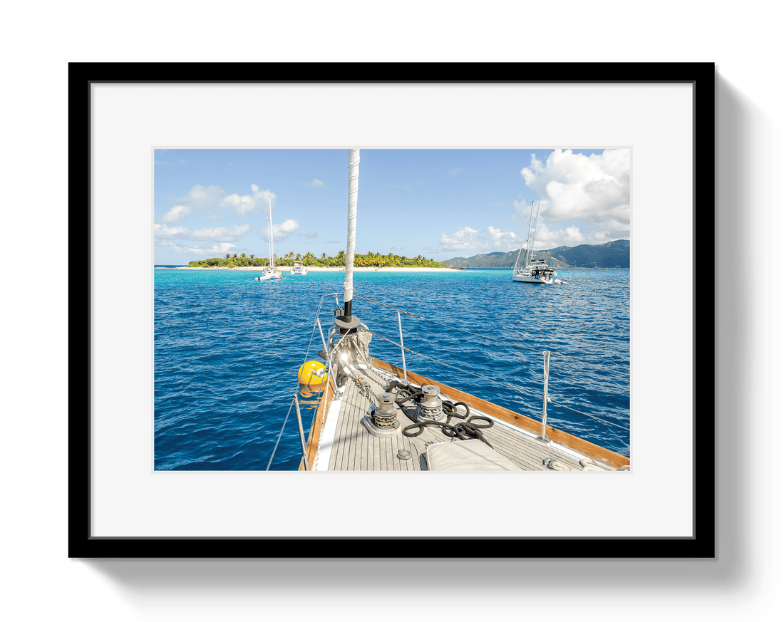 Framed photograph of a sailboat on a clear day with blue water and white clouds.